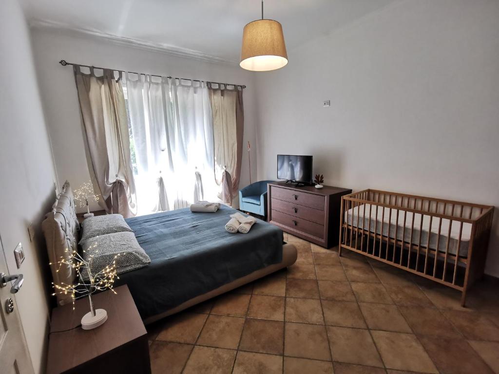 1 dormitorio con 1 cama, 1 cuna y TV en Cuncè en Anguillara Sabazia