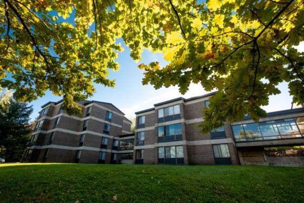 un grand bâtiment en face d'une pelouse dans l'établissement Au Campus, à Sherbrooke
