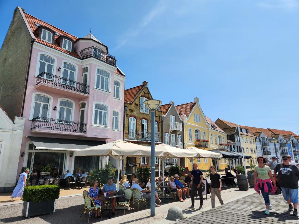 un grupo de personas caminando por una calle con edificios en Harbour Walk, en Sønderborg