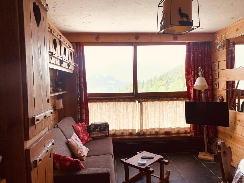 een woonkamer met een bank en een groot raam bij Studio Les Arcs 1600, 1 pièce, 3 personnes - FR-1-411-468 in Arc 1600