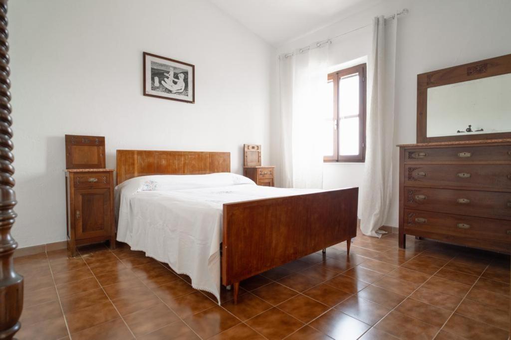 um quarto com uma cama, uma cómoda e um espelho em casa Luciana em Rio nellʼElba