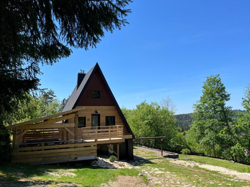 une grande cabane en bois avec un toit en gambrel dans l'établissement Chalet du Fayard - jacuzzi avec vue et détente en pleine nature, à Belfahy