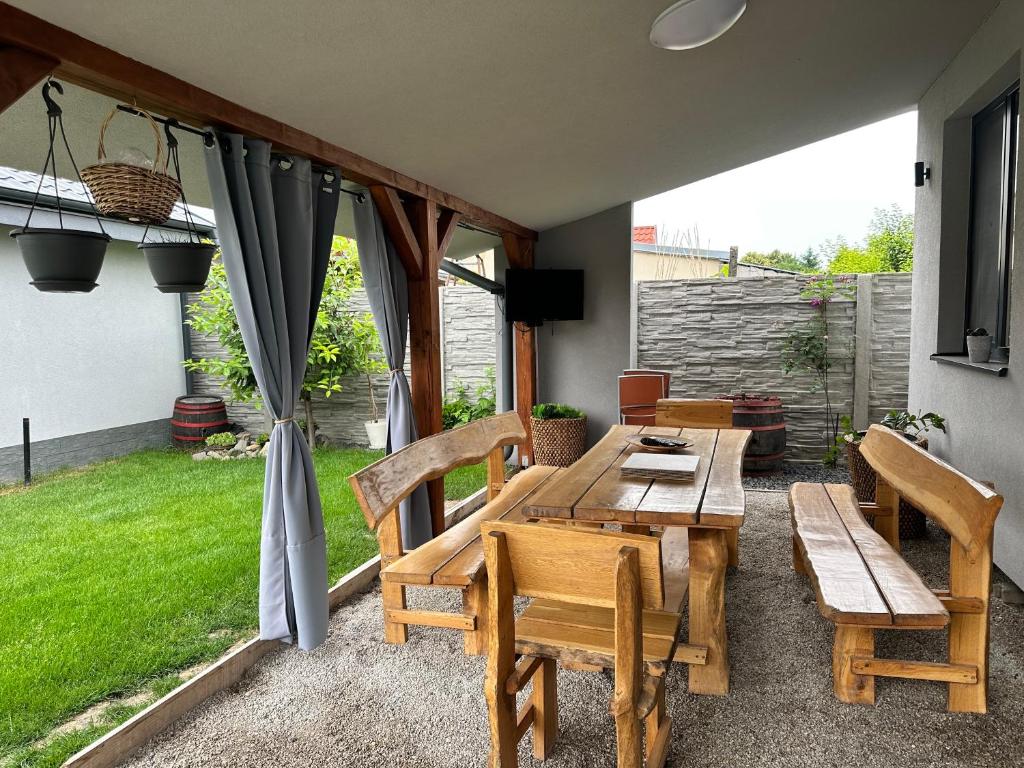 eine Terrasse mit einem Holztisch und Stühlen in der Unterkunft Víkendový dom Hlboká in Dunajská Streda