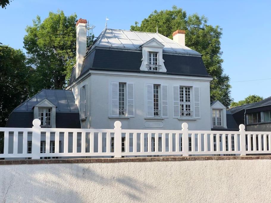 a white fence in front of a white house at La Ninette du Domaine de Maubuisson in Ver-sur-Mer