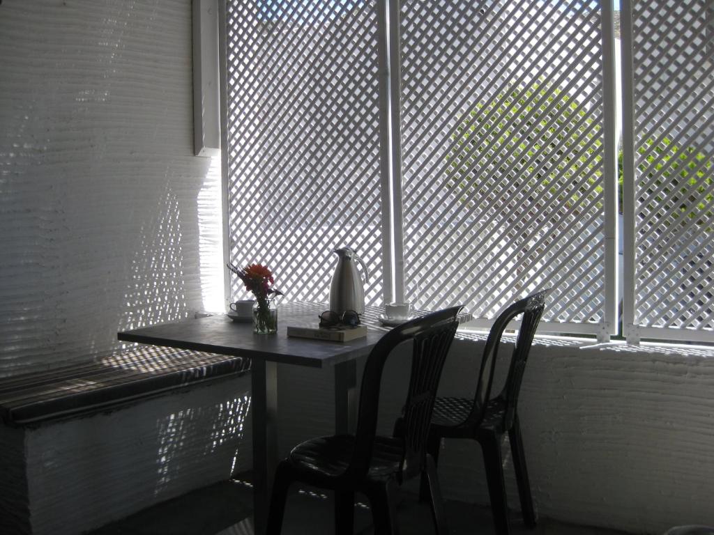 a table and two chairs in front of a window at RESTIA in Agios Petros
