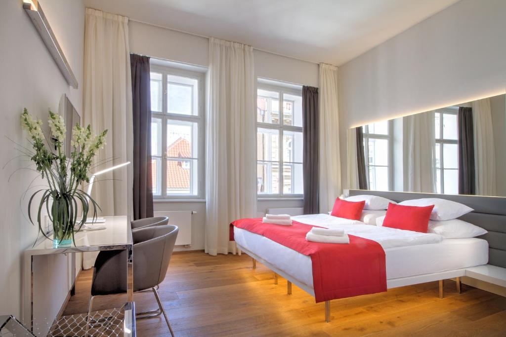 1 dormitorio con 1 cama blanca grande con almohadas rojas en Bishop's House en Praga