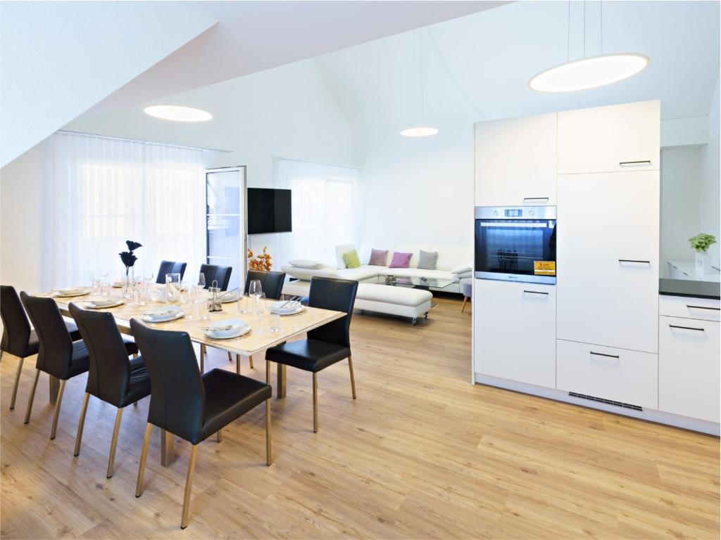 Exklusive 4.5 Zimmer Wohnung für Familien und Business في Eschenz: مطبخ وغرفة طعام مع طاولة وكراسي