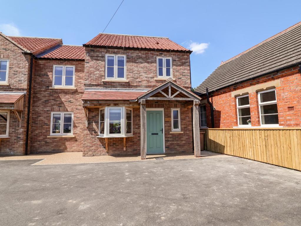 a large brick house with a green door at Keepers Cottage in York