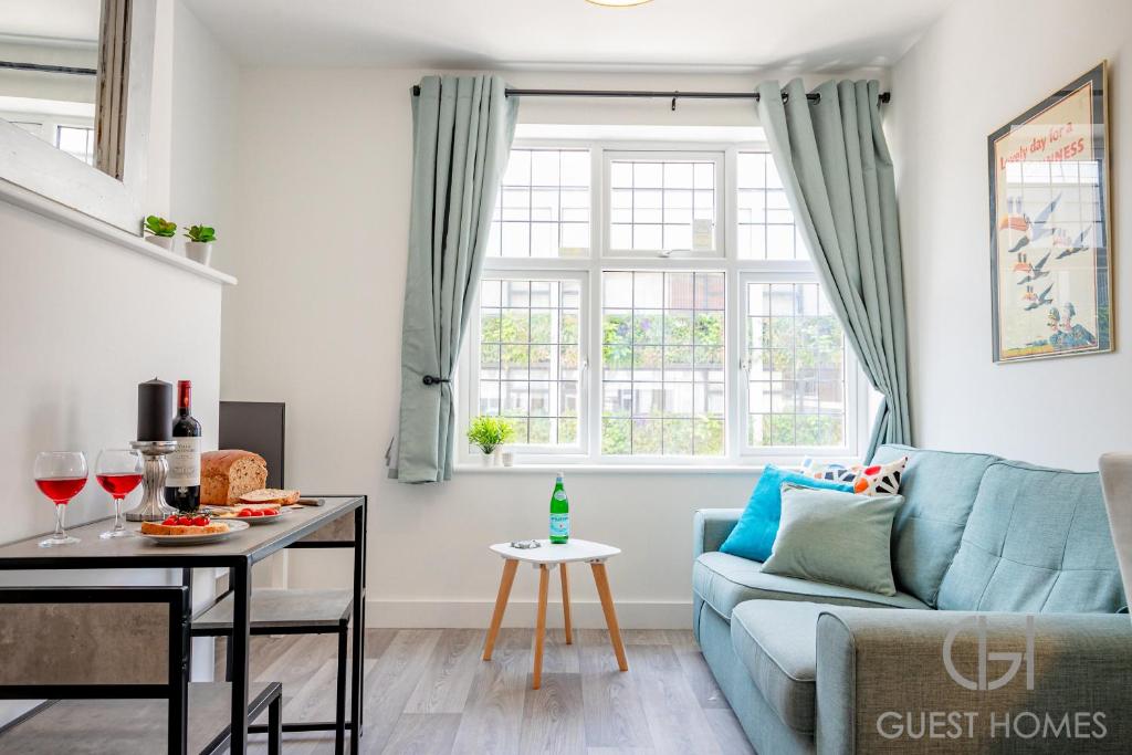 Guest Homes - Croydon Road Apartments في كاترهام: غرفة معيشة مع أريكة زرقاء وطاولة