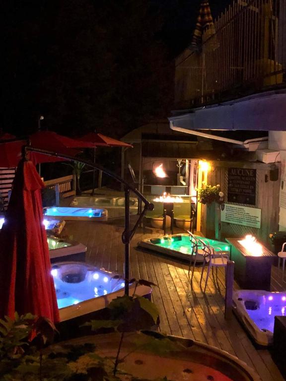 a swimming pool with lights on a deck at night at Auberge Hotel Spa Watel in Sainte-Agathe-des-Monts