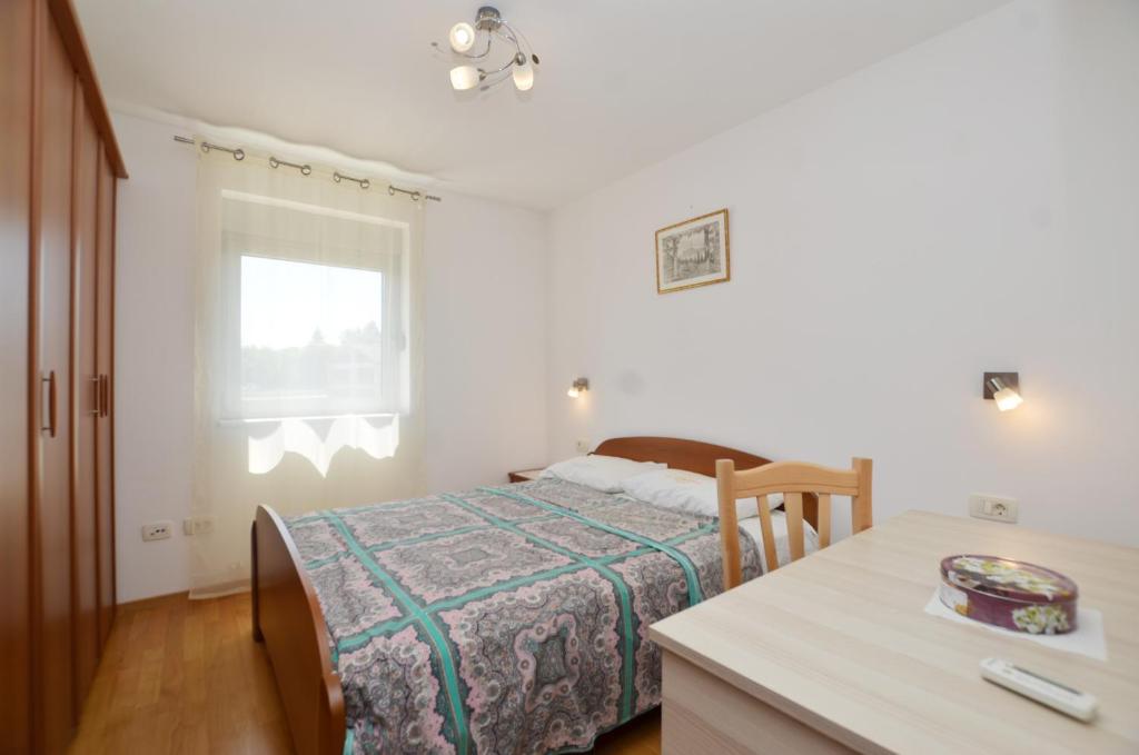 a bedroom with a bed and a table and a window at Miro Apartment in Rovinj