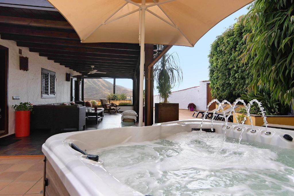 a bath tub with an umbrella on a patio at Los Jazmines in Agaete