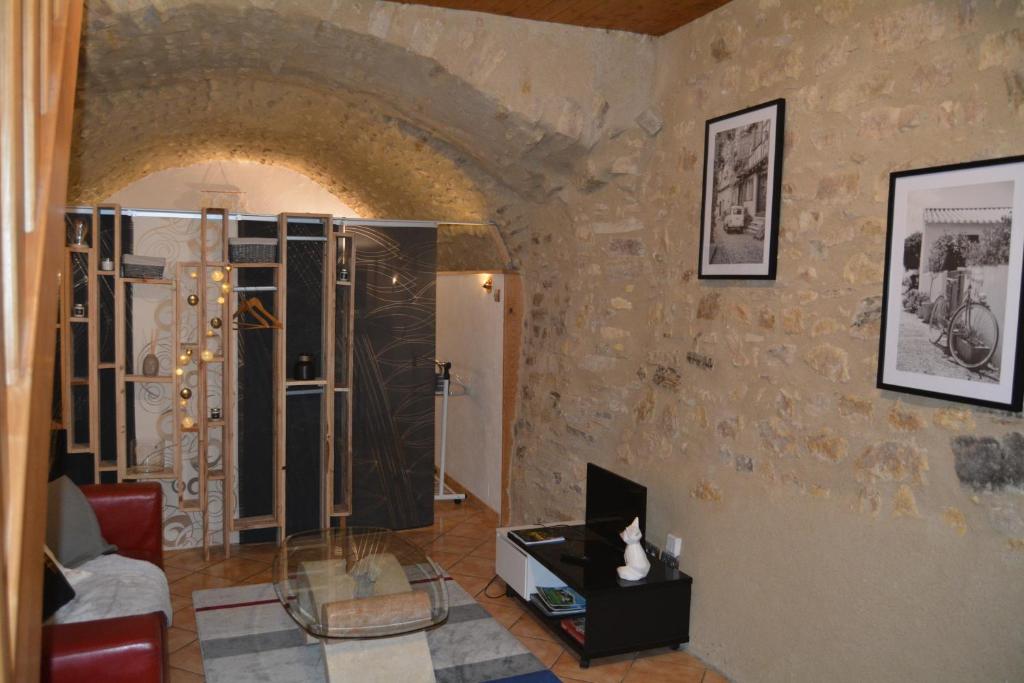 a living room with a stone wall at maison de bourg en pierre in Saint-Maurice