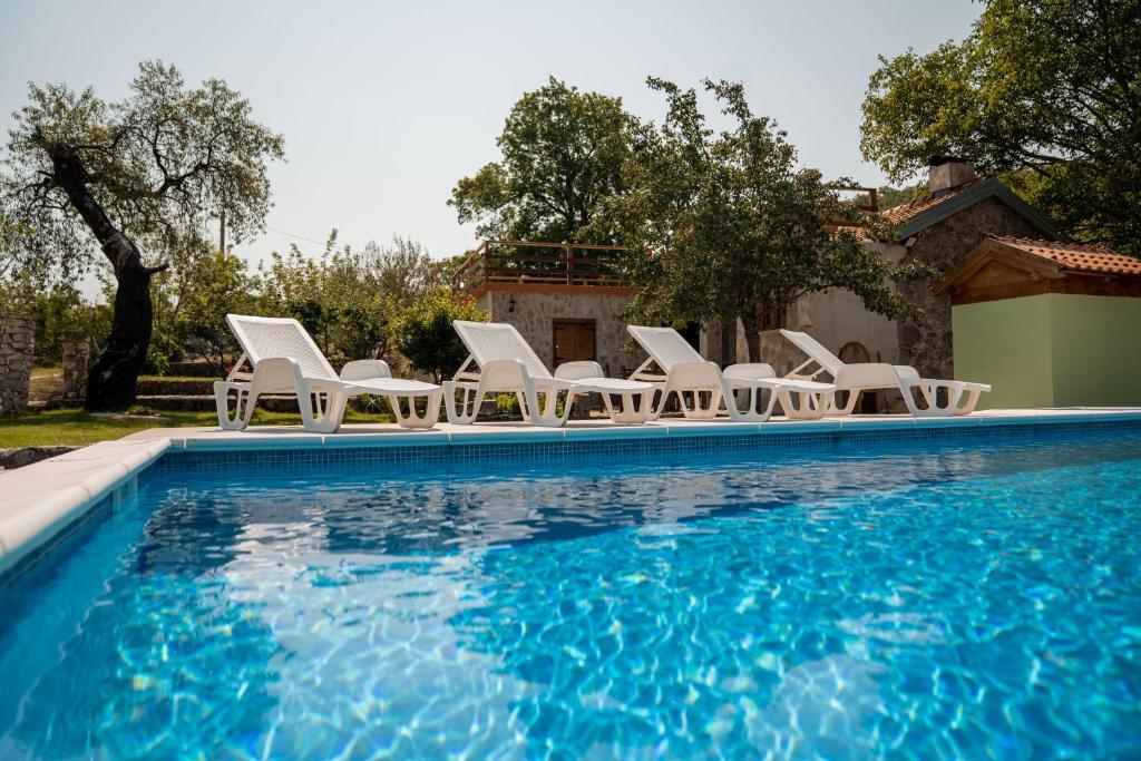 un grupo de sillas y una piscina en Villa Mramor, en Neum