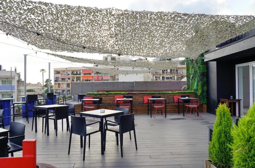 a patio with tables and chairs on a building at Lloret Vibe Affiliated by FERGUS in Lloret de Mar
