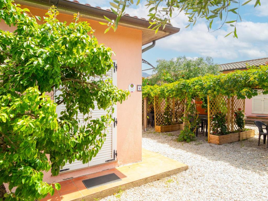 uma casa com uma porta branca e algumas árvores em Appartamenti Il Mare e La Quiete em Portoferraio