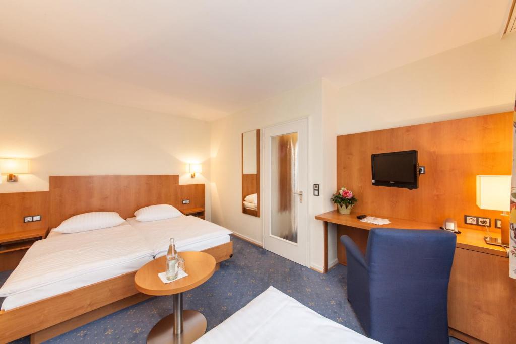 Postel nebo postele na pokoji v ubytování Hotel Drei Kronen Elmshorn