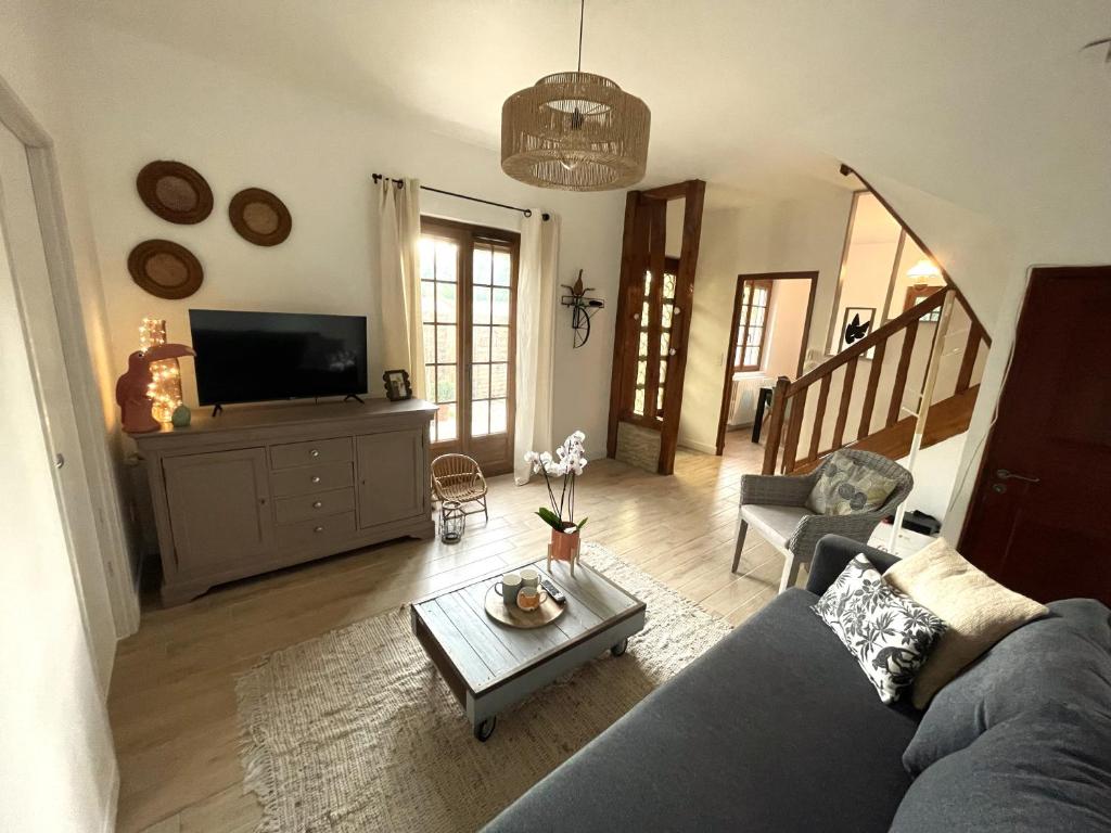 un soggiorno con divano blu e TV di Maison complète Normandie proche Giverny a Vernon