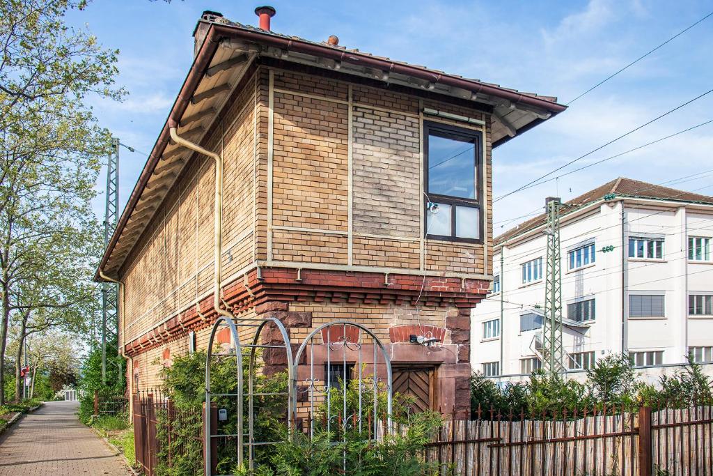 a brick house with a large window on top of it at Historisches Stellwerk mit Garten in bester Innenstadtlage & Boxspringbetten nahe der Schweizer Grenze in Lörrach