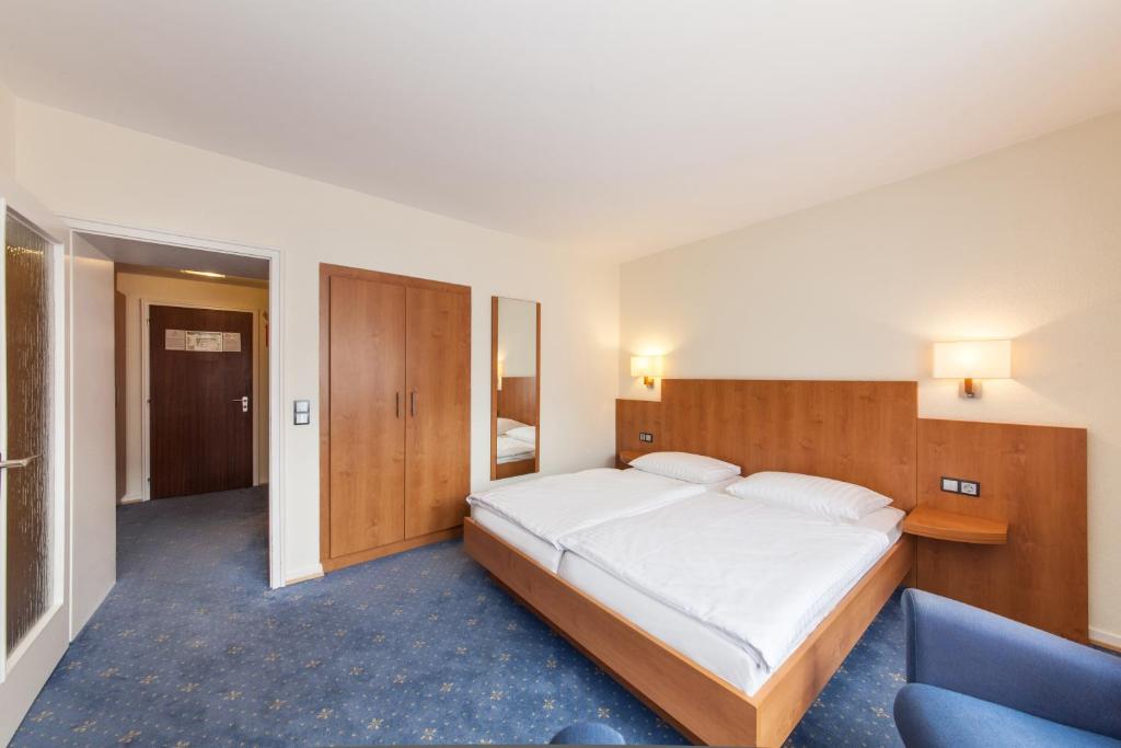 Postel nebo postele na pokoji v ubytování Hotel Drei Kronen Elmshorn