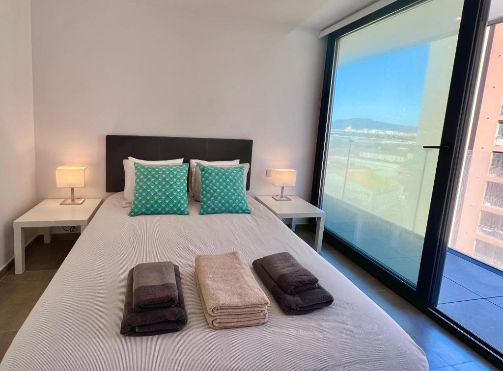 een slaapkamer met een groot bed en 2 handdoeken bij Spacious 1 Bed Apartment With Ocean View Balcony in Gibraltar