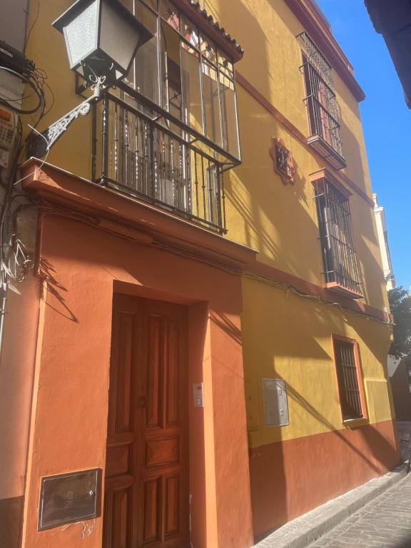 Un edificio amarillo y naranja con una puerta y un balcón. en Moratin n3 apartamento 150m2 en el centro, en Sevilla