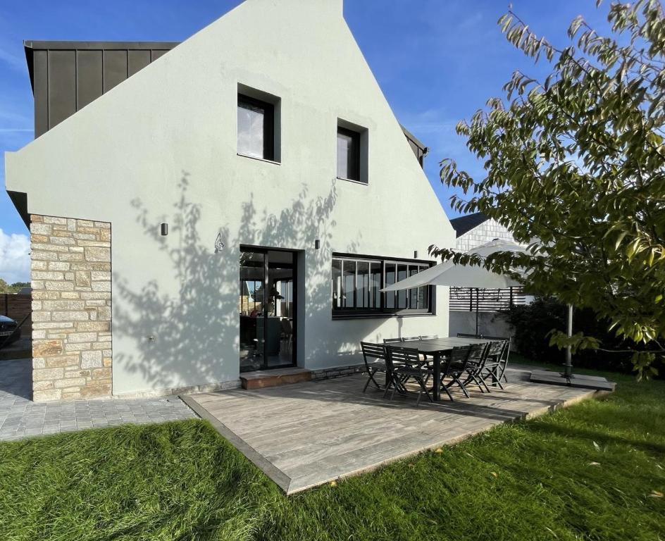 une maison blanche avec une table devant elle dans l'établissement Les pieds dans l o a Port navalo, à Arzon
