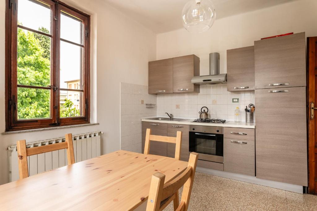 a kitchen with a wooden table and a dining room at Apartments Volpino - Affitti Brevi Italia in Lucca