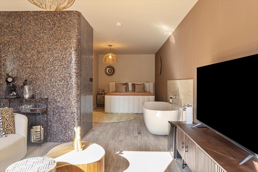 a bathroom with a tub and a tv in a room at Het Oude Stadhuis in Enschede