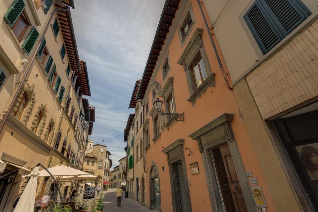 a person walking down a street next to buildings at Palazzo Tempi in San Casciano in Val di Pesa