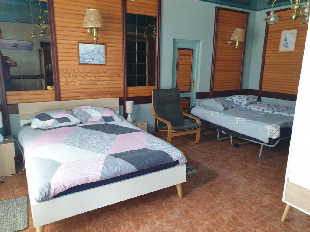 a bedroom with a bed and a bed and a bench at Ty Keramor in Hôpital-Camfrout