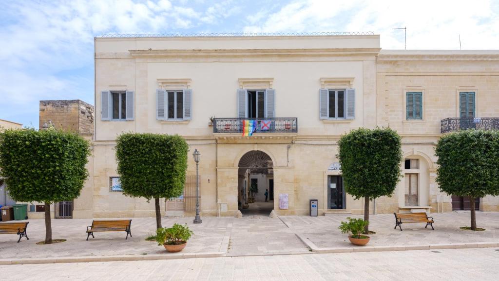 een gebouw met banken en bomen ervoor bij Italianway - Dammuso San Cesario in San Cesario di Lecce