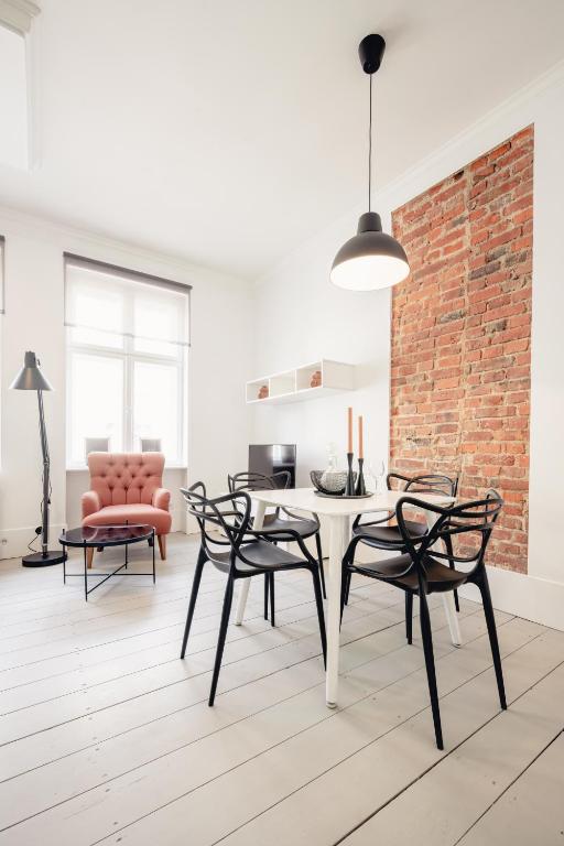 a dining room with a table and chairs and a brick wall at Apartamenty Woźna 14a, 2 rooms, self check in 24h in Poznań