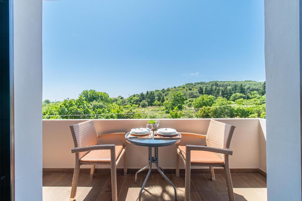 a table and chairs on a balcony with a view at Angel's Studio 4 in Agios Georgios Pagon