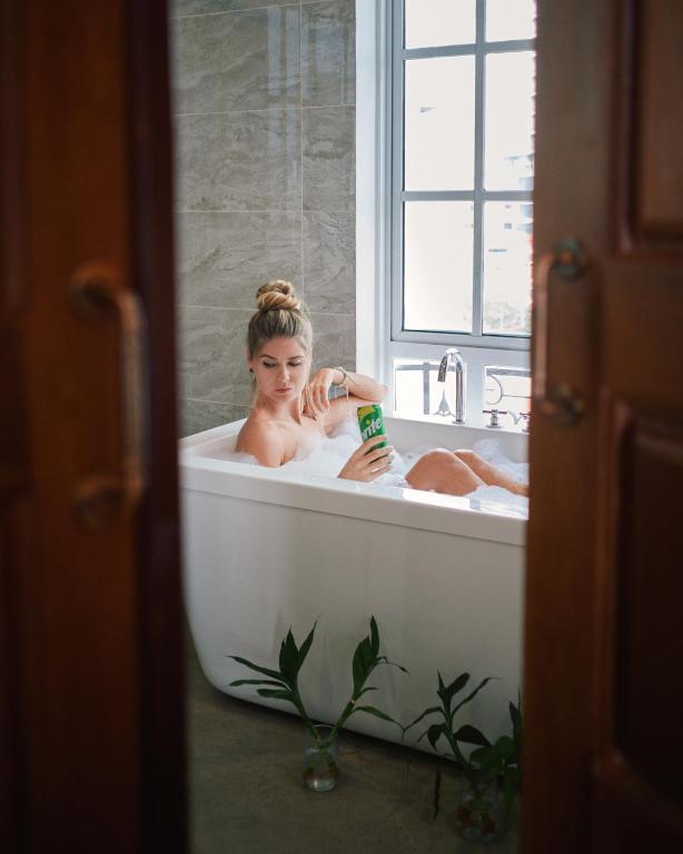 une femme prenant un bain dans une baignoire dans l'établissement Mettavary Hotel, à Phnom Penh