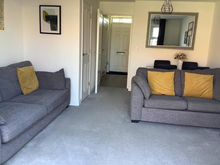 ein Wohnzimmer mit 2 Sofas und einem Spiegel in der Unterkunft Entire 2 bedroom house in Tamworth in Tamworth
