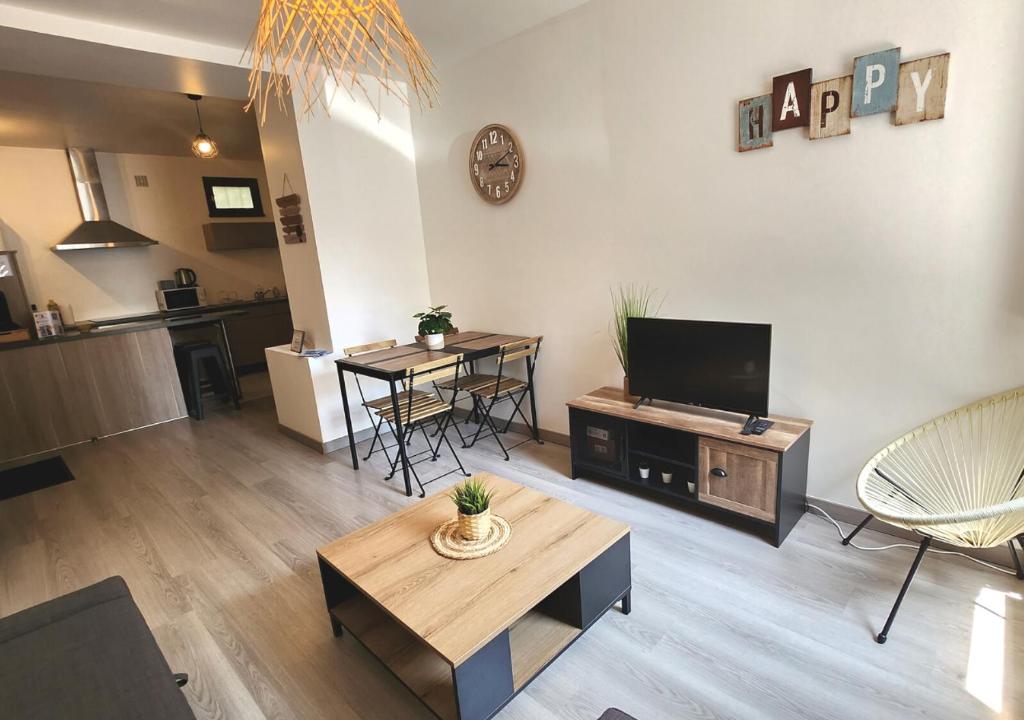 a living room with a flat screen tv and a table at "Cozy Zen" 1 grande chambre - Calme - Arrivée autonome - 6 pers - Parking gratuit in Tours