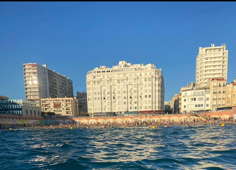 un groupe de personnes sur l'eau devant des bâtiments dans l'établissement Les catalans, vue mer, à Marseille