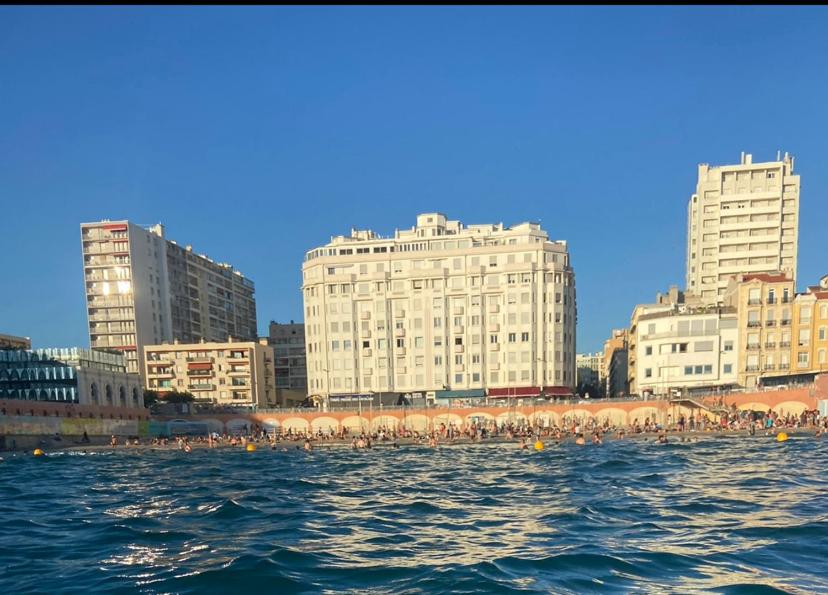 een groep mensen op het water voor gebouwen bij Les catalans, vue mer in Marseille