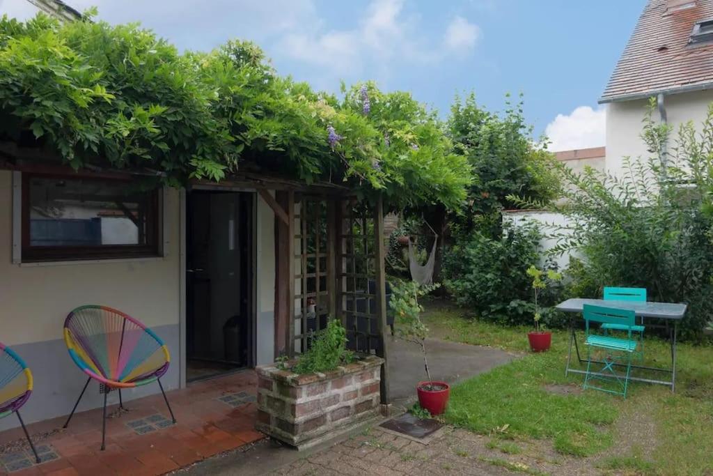 un patio con sillas y una mesa en Agréable maison de ville solognote avec jardin en Olivet