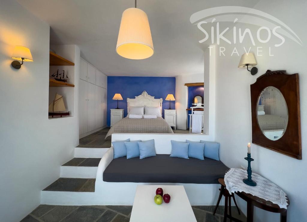 a bedroom with a large bed with blue pillows at Traditional Maisonette with picturesque Chora View in Chora Folegandros