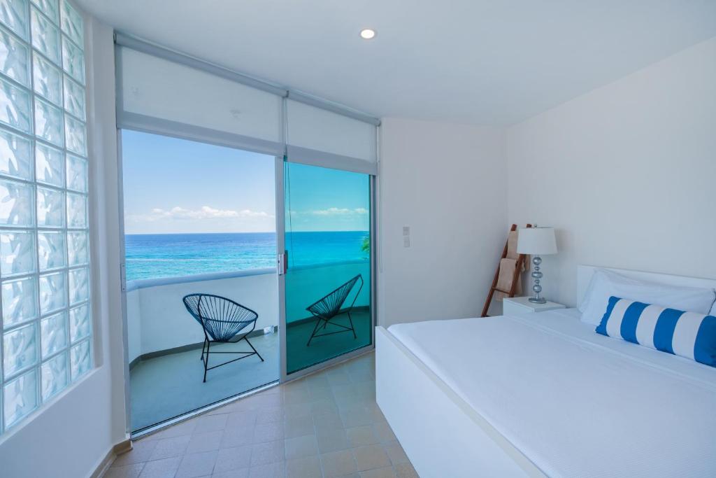 a bedroom with a bed and a view of the ocean at Suites Turquesa in Cozumel