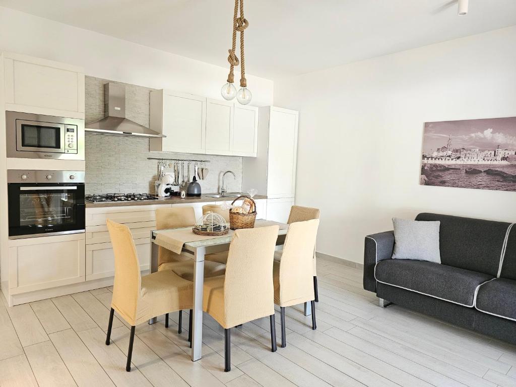Una cocina y una sala de estar con mesa y sillas. en Casa Elia - Puglia Mia Apartments, en Monopoli