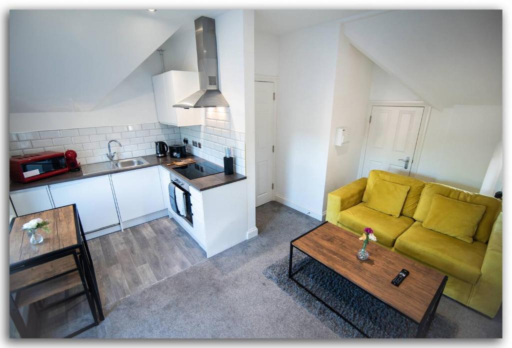 a living room with a yellow couch and a table at Adorable Flat in Maidstone - Sleeps 3 in Kent