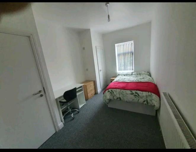 een slaapkamer met een bed, een bureau en een raam bij Private Room Ensuite D Burnley city in Burnley