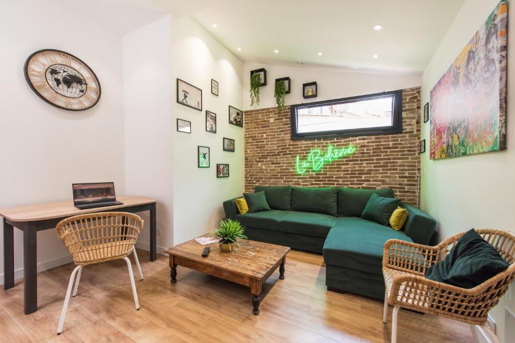 uma sala de estar com um sofá verde e uma mesa em Bel appart rénové - la bohème em Hyères
