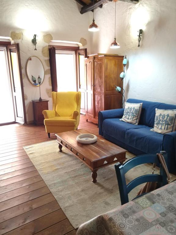 uma sala de estar com um sofá azul e uma cadeira amarela em Oldtown romantic apartment em Cagliari