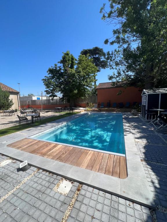 a small swimming pool with a wooden deck at Hotel-Restaurant Saint Romain Logis in Anse