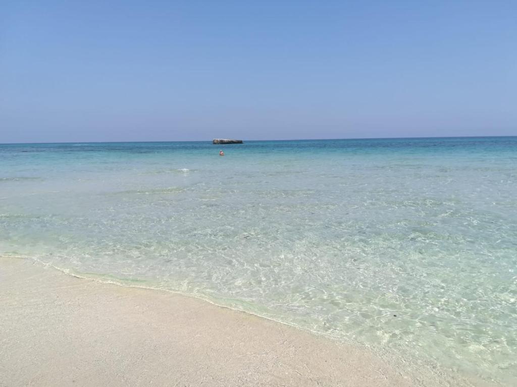 una playa de arena con el océano al fondo en LA BELLA VOLTA - elegant rooms, en Gallipoli