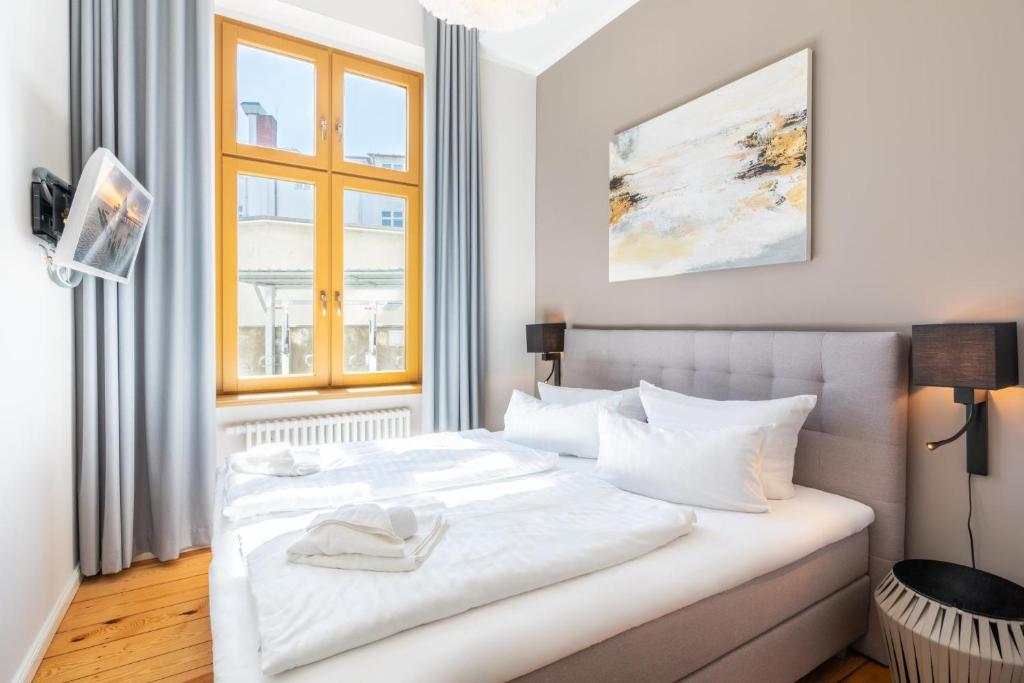 a white bed in a room with a window at Großzügige Designer- Luxuswohnung für 2 Personen in stilvoller Altbauvilla in Heringsdorf